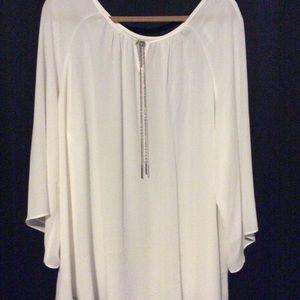 Cream colored, chiffon blouse with gold chains.